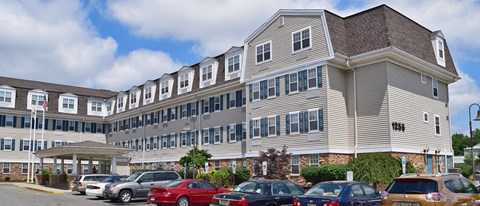 a large apartment building with cars parked in front of it